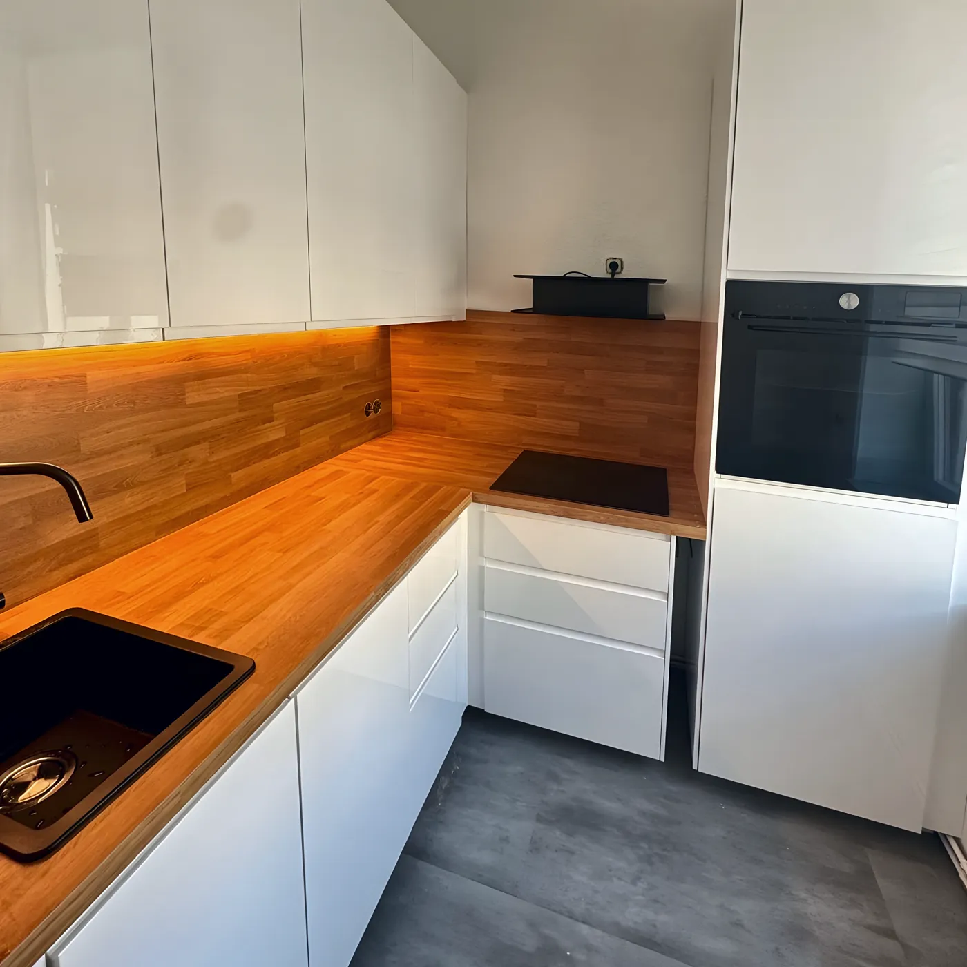Dieselbe Küche mit Backofen im Hochschrank.